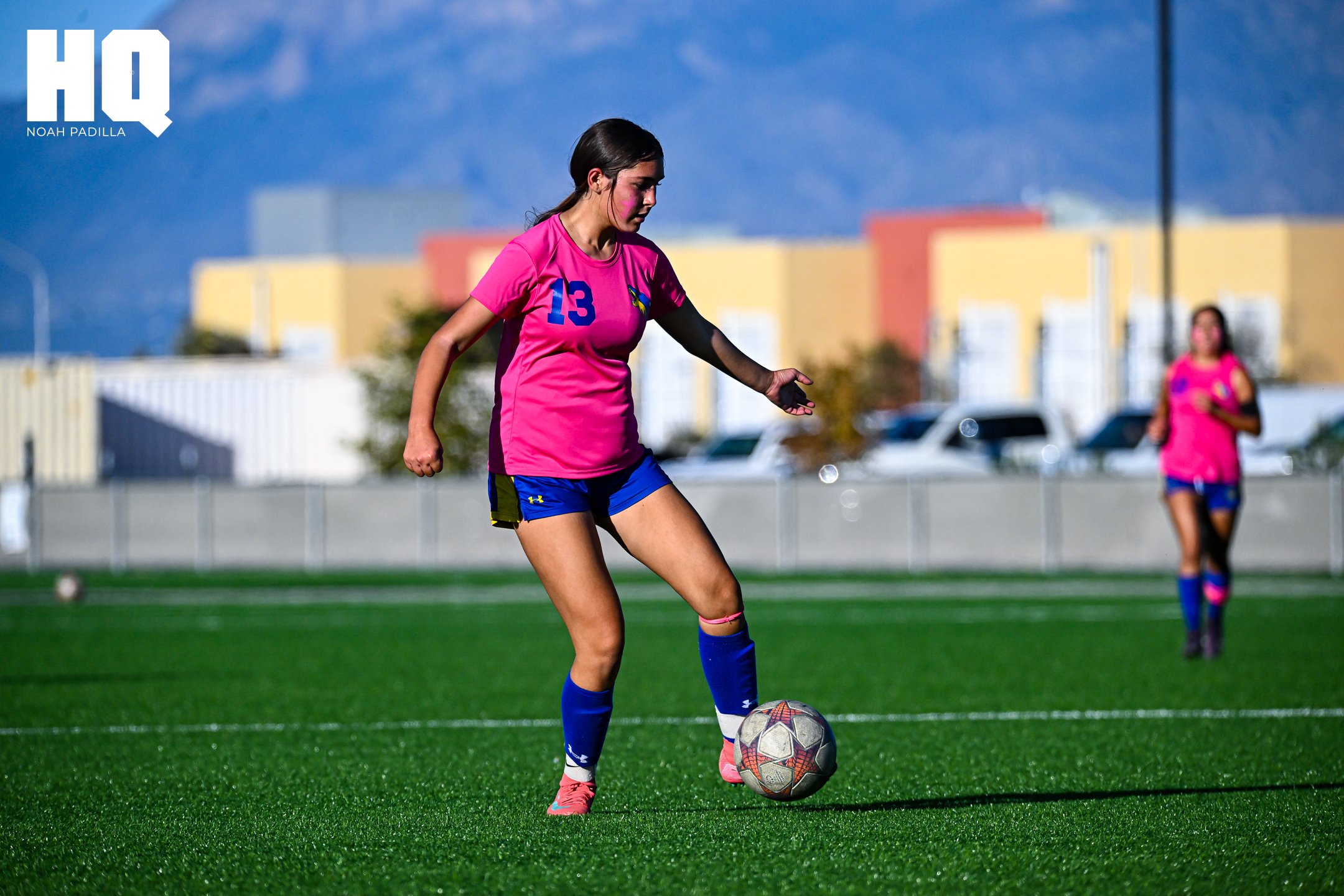 Cottonwood Classical girls soccer player, Hailo Baca, in a pink jersey with number 13 controls the ball in open space with focus, preparing for a play while a teammate runs in support in the background.